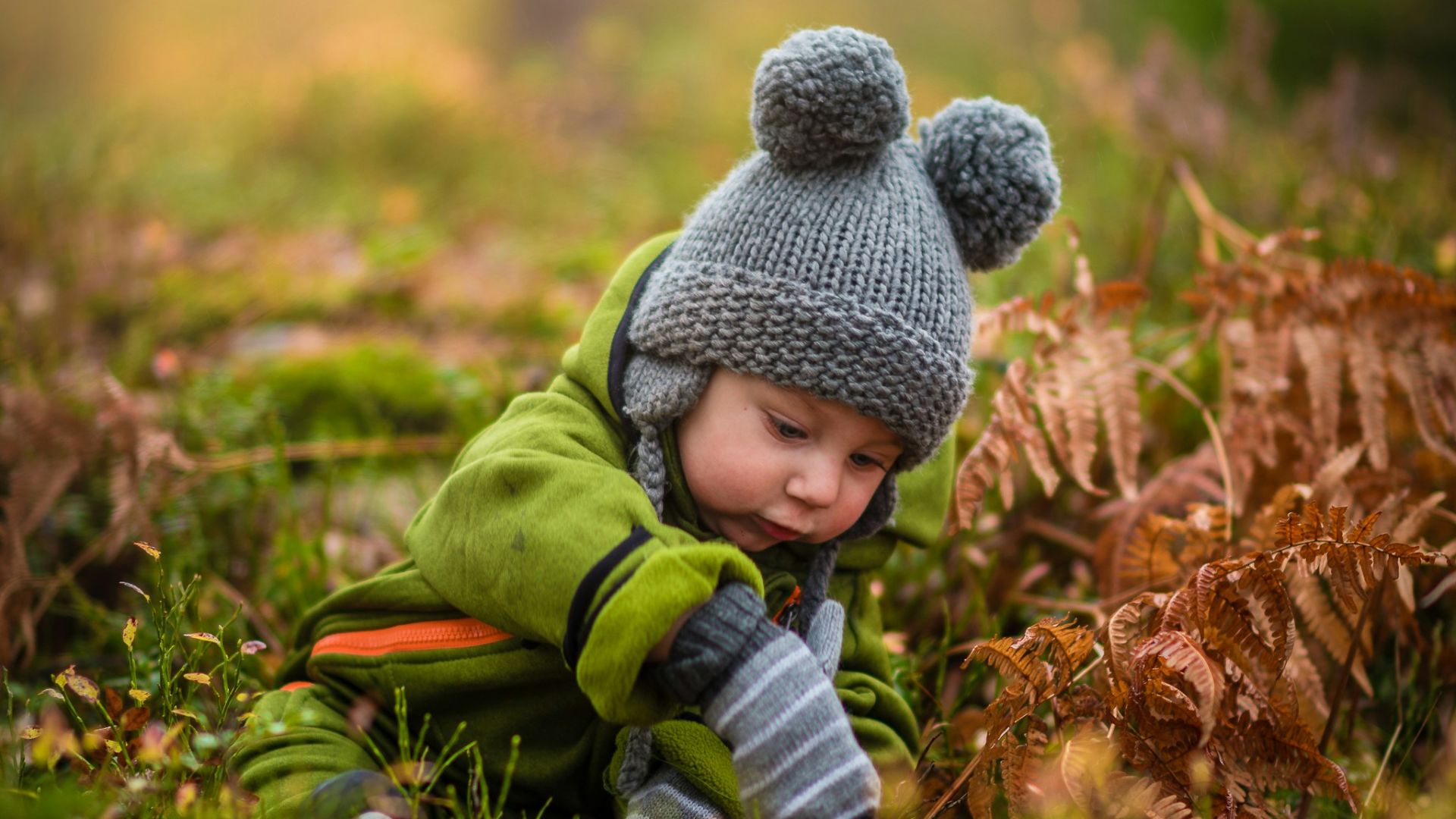 selective focus photo of baby on green grass field