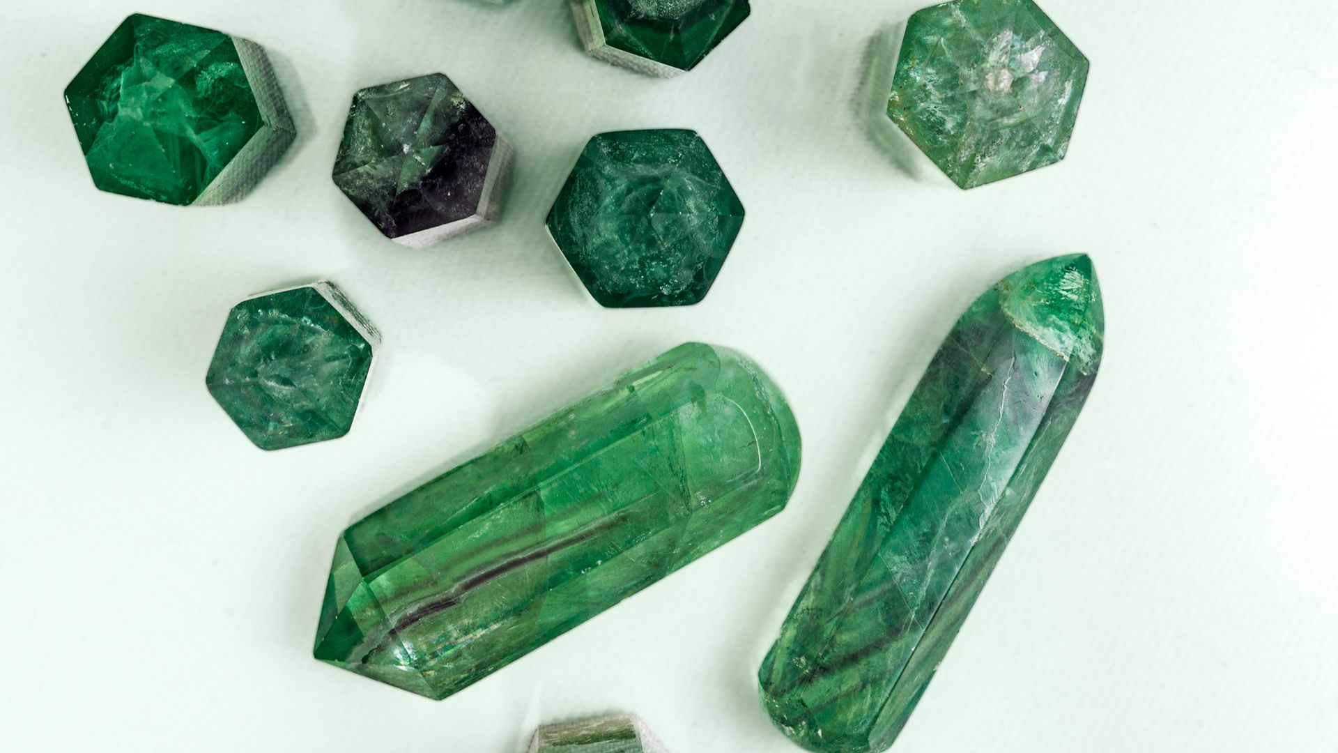 a group of green crystals sitting on top of a white table