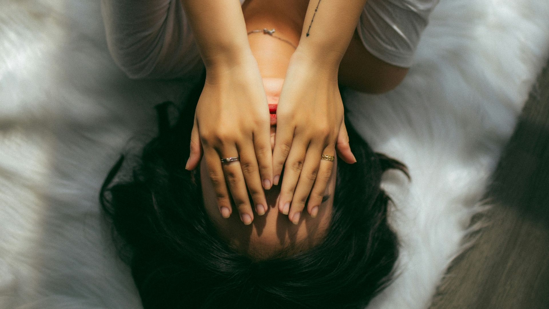 a woman holds her hands over her face