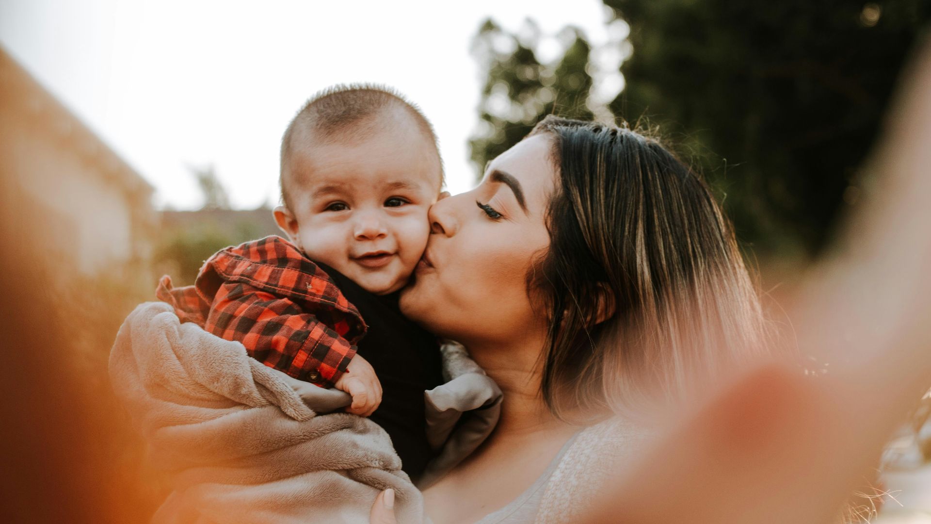 woman kiss a baby while taking picture