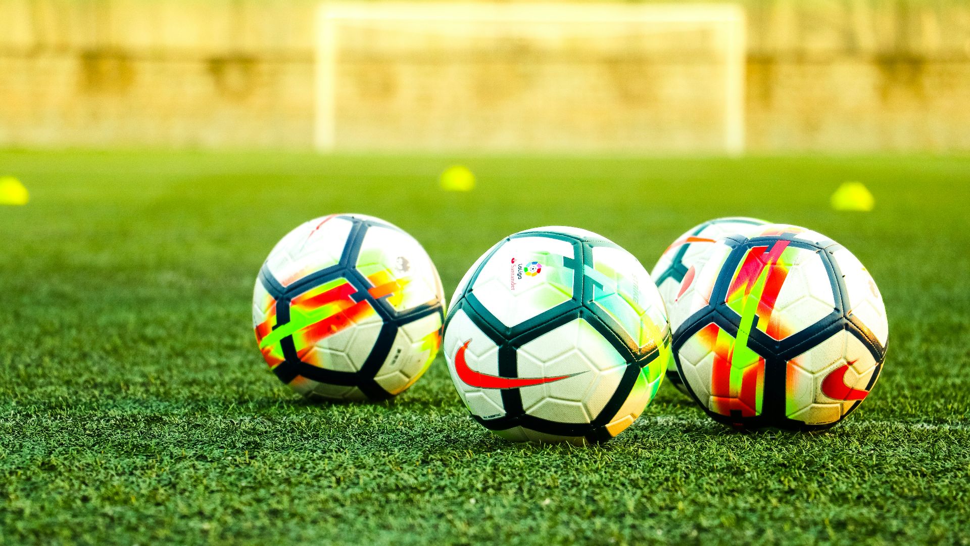 three white-and-black soccer balls on field