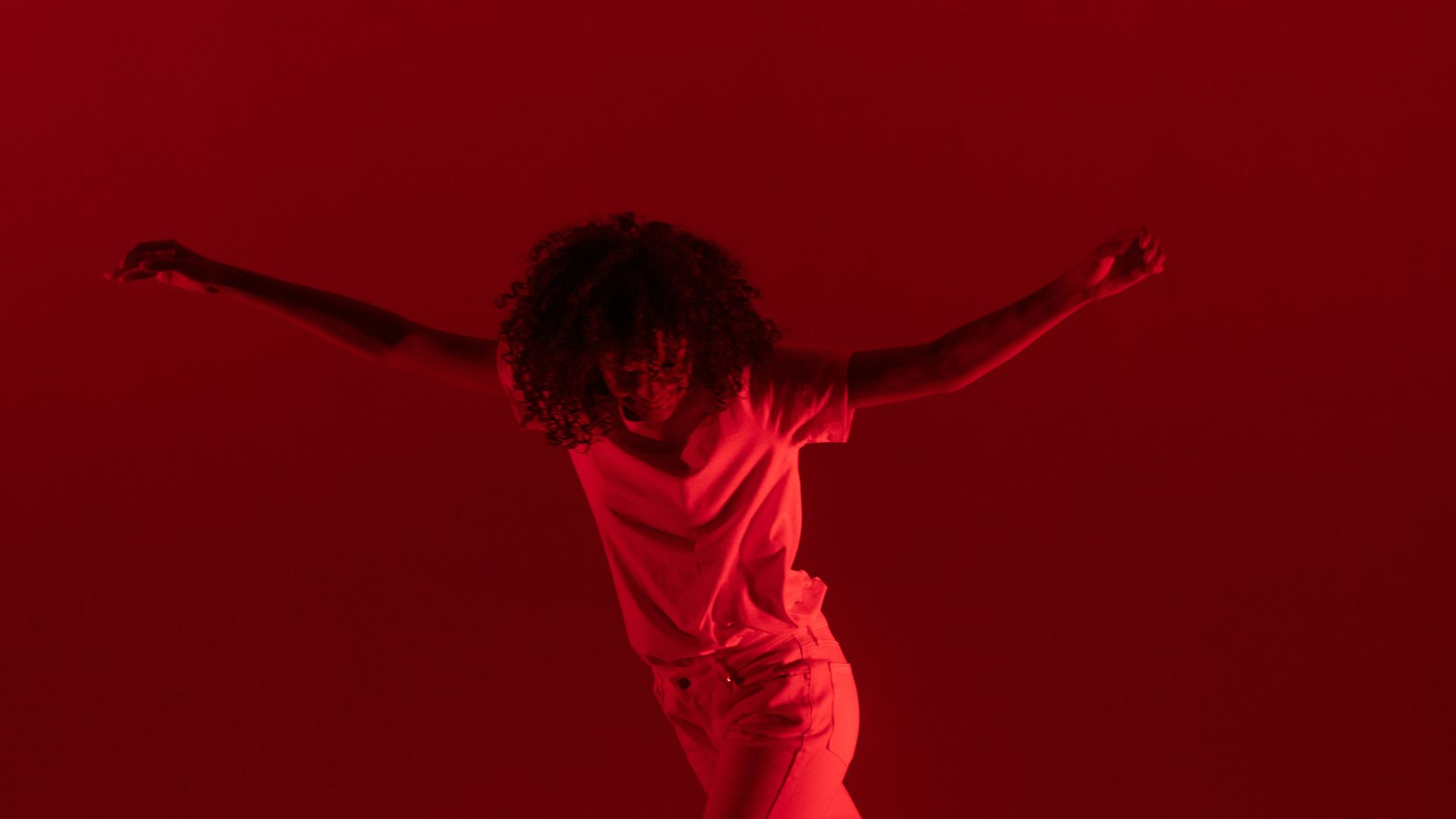 photography of woman dancing near red background