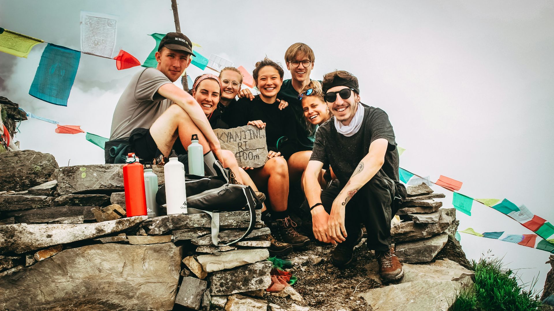group picture of men and women on hill at daytime