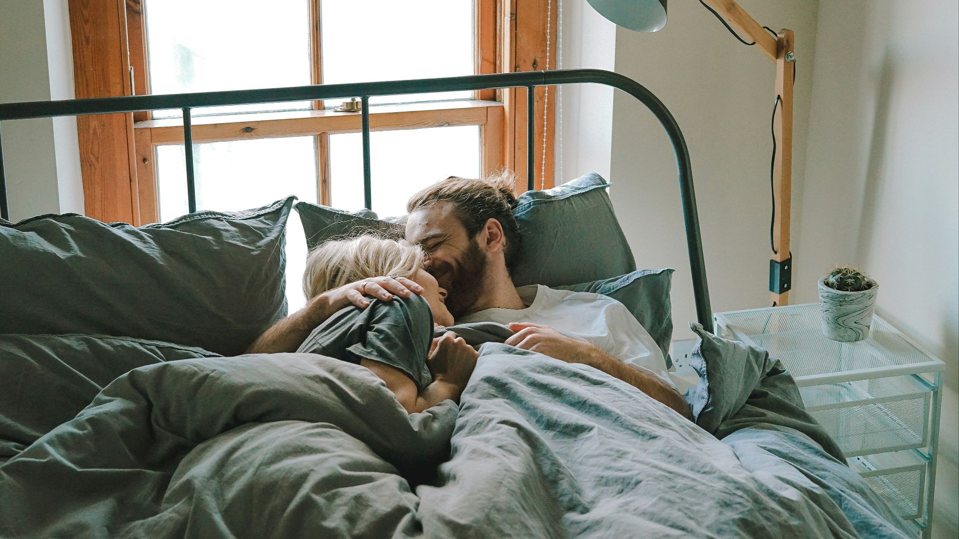 man kissing woman on her forehead