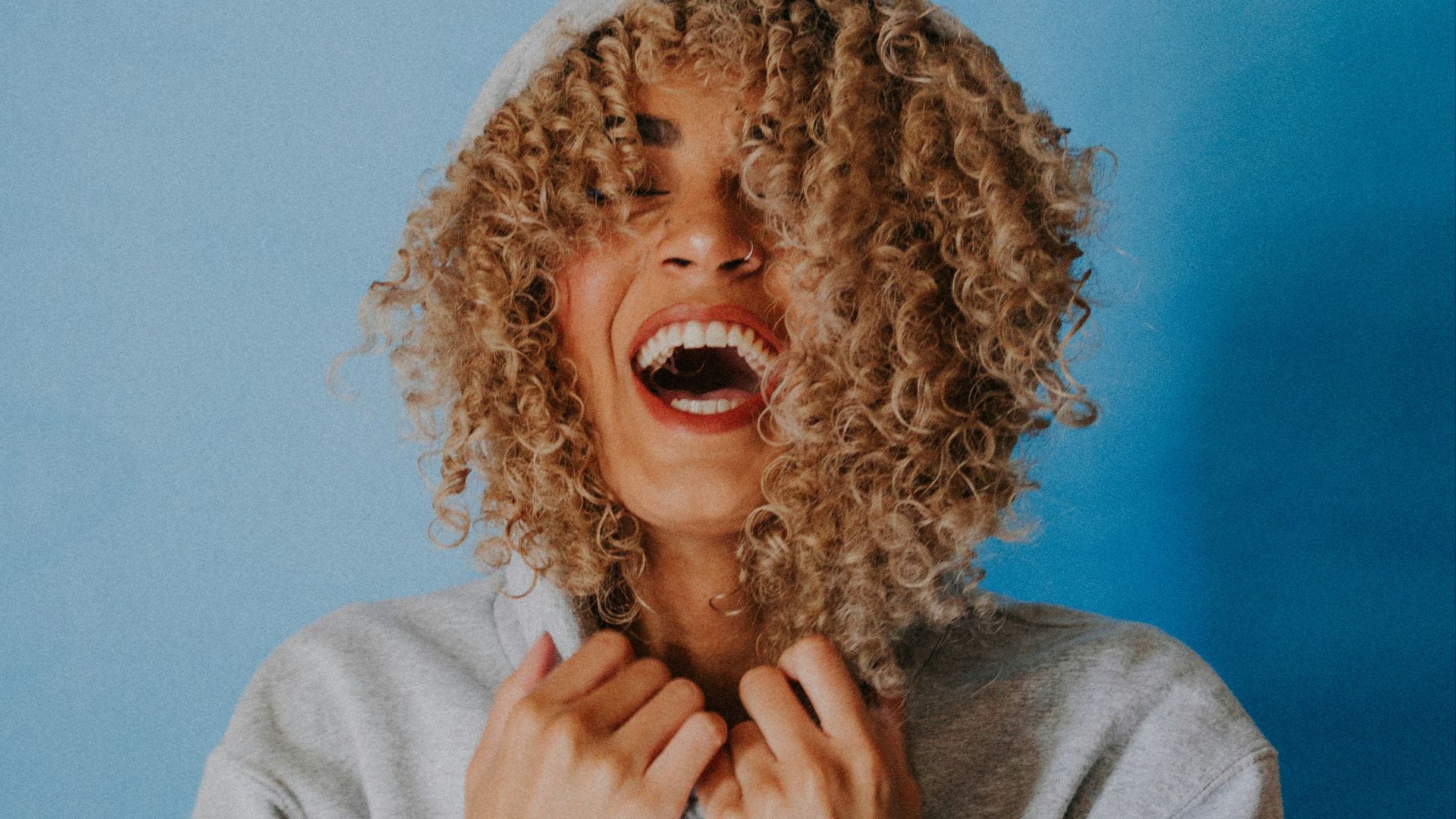 smiling woman wearing gray hoodie
