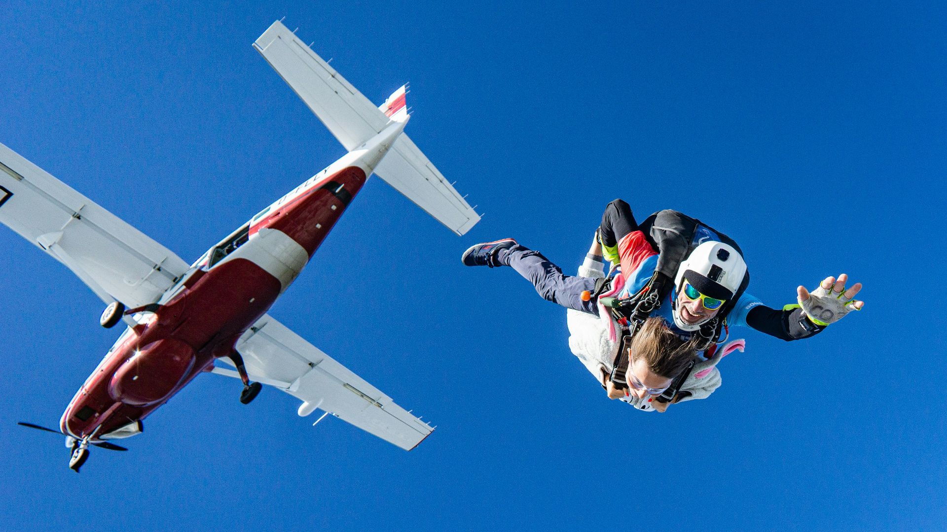 white and red airplane in mid air during daytime