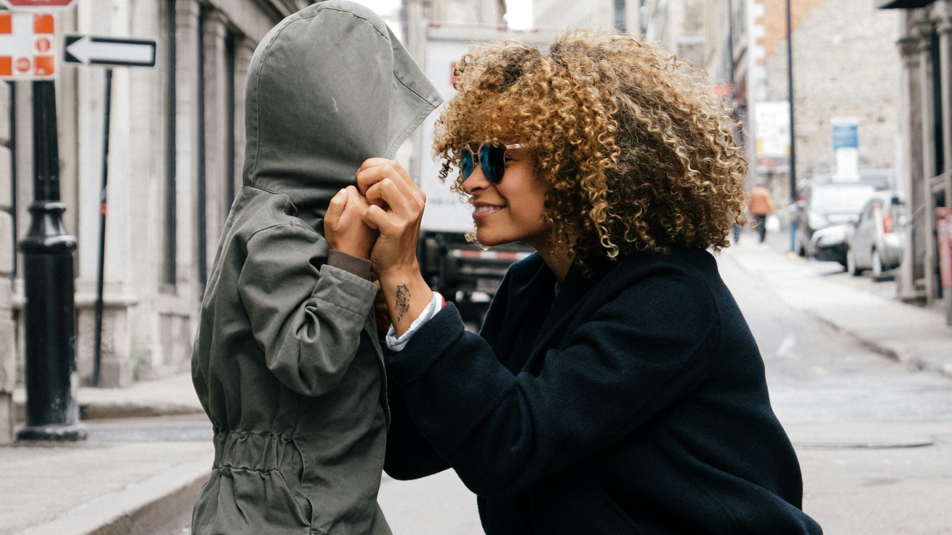 woman holding kid at the street