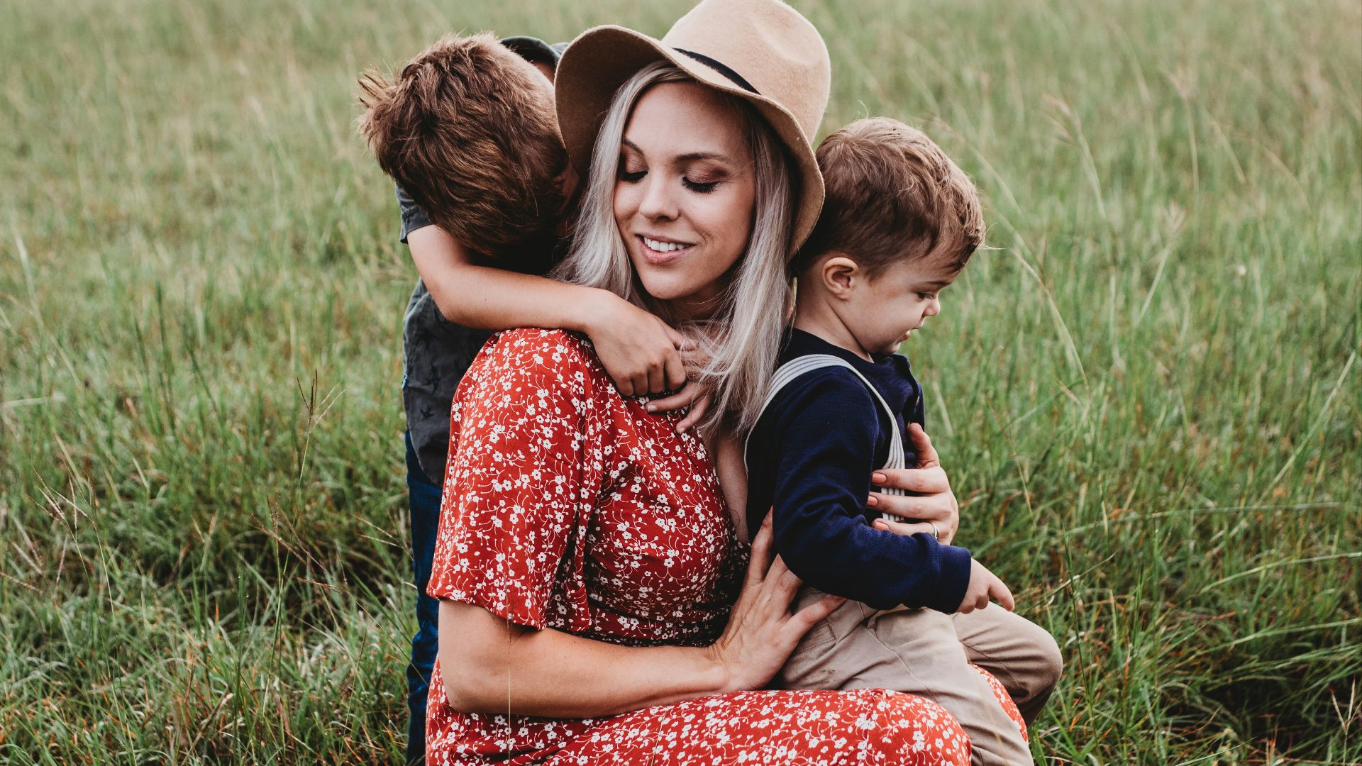 man and two children on grass field