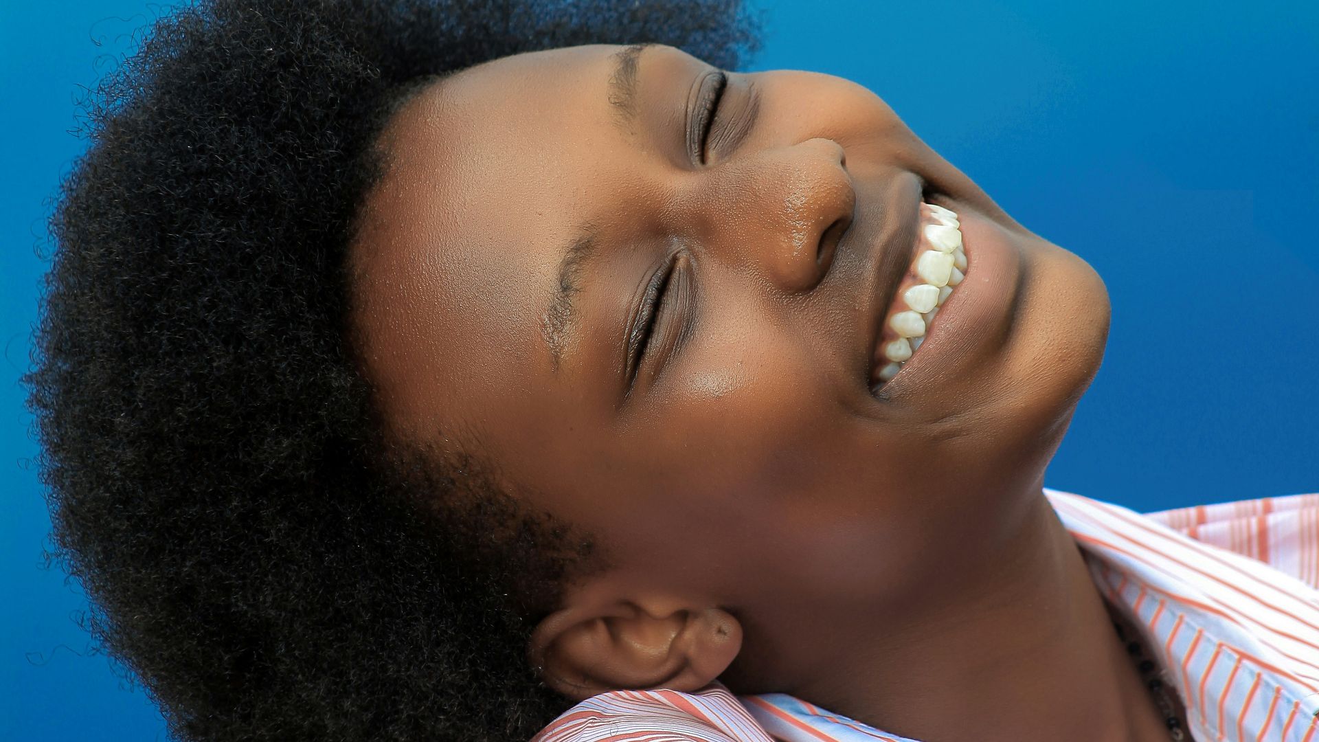 smiling girl in pink and white stripe shirt
