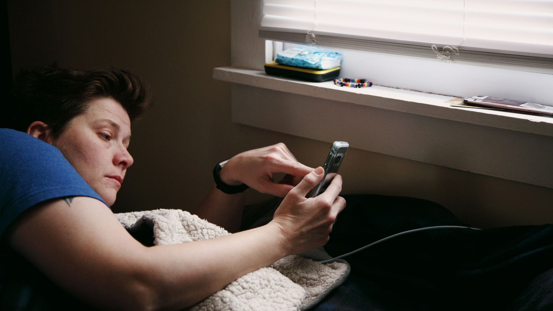 man in black shirt holding black smartphone