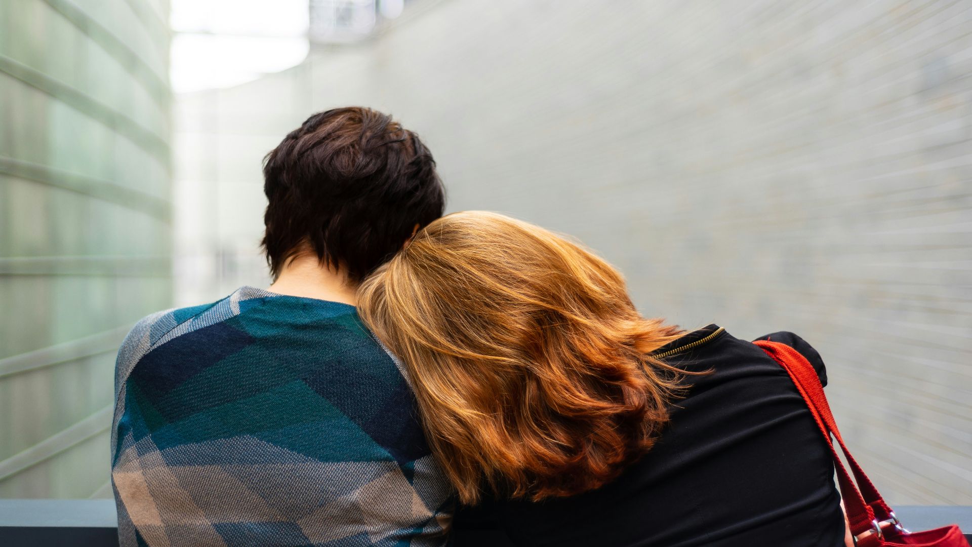 a woman rests her head on another person's shoulder