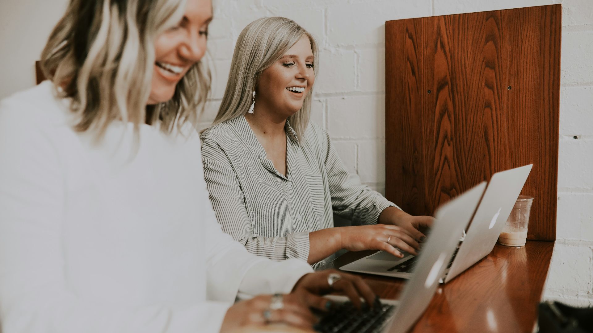 two women using laptops