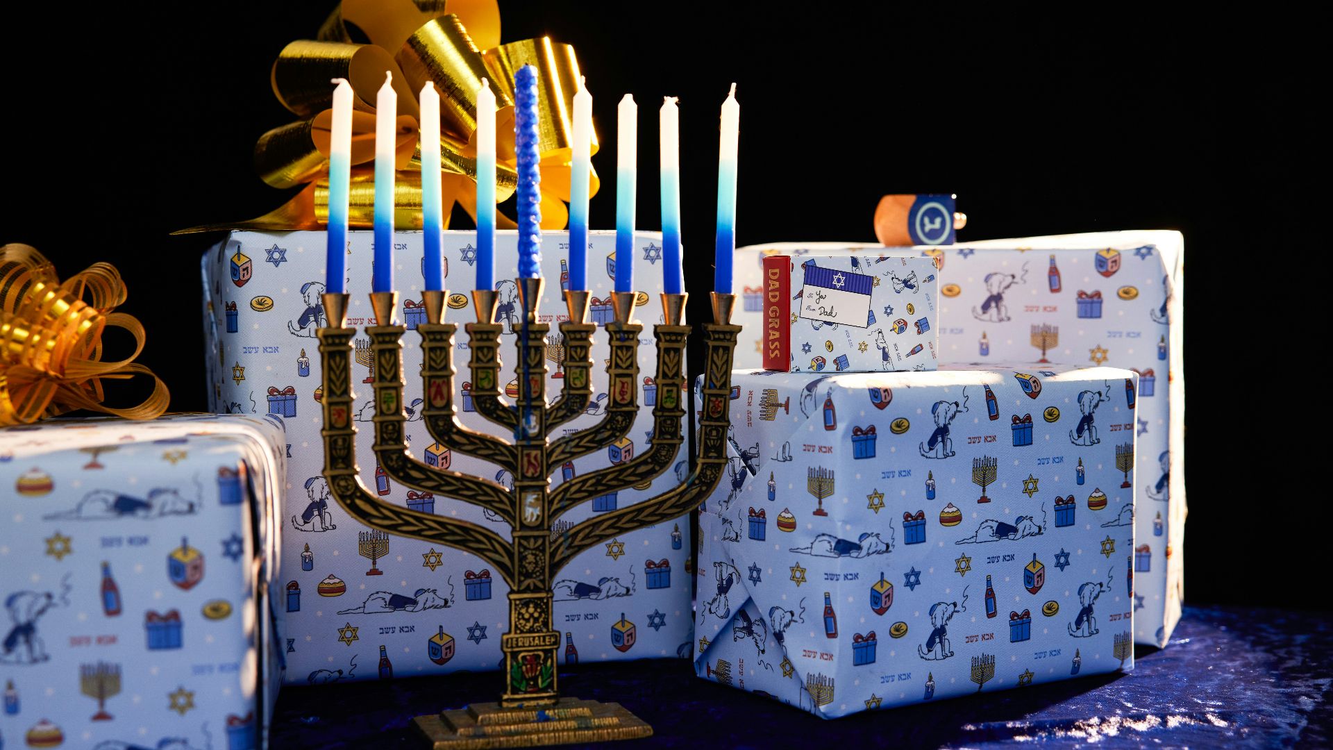 a lit menorah and gift boxes on a table