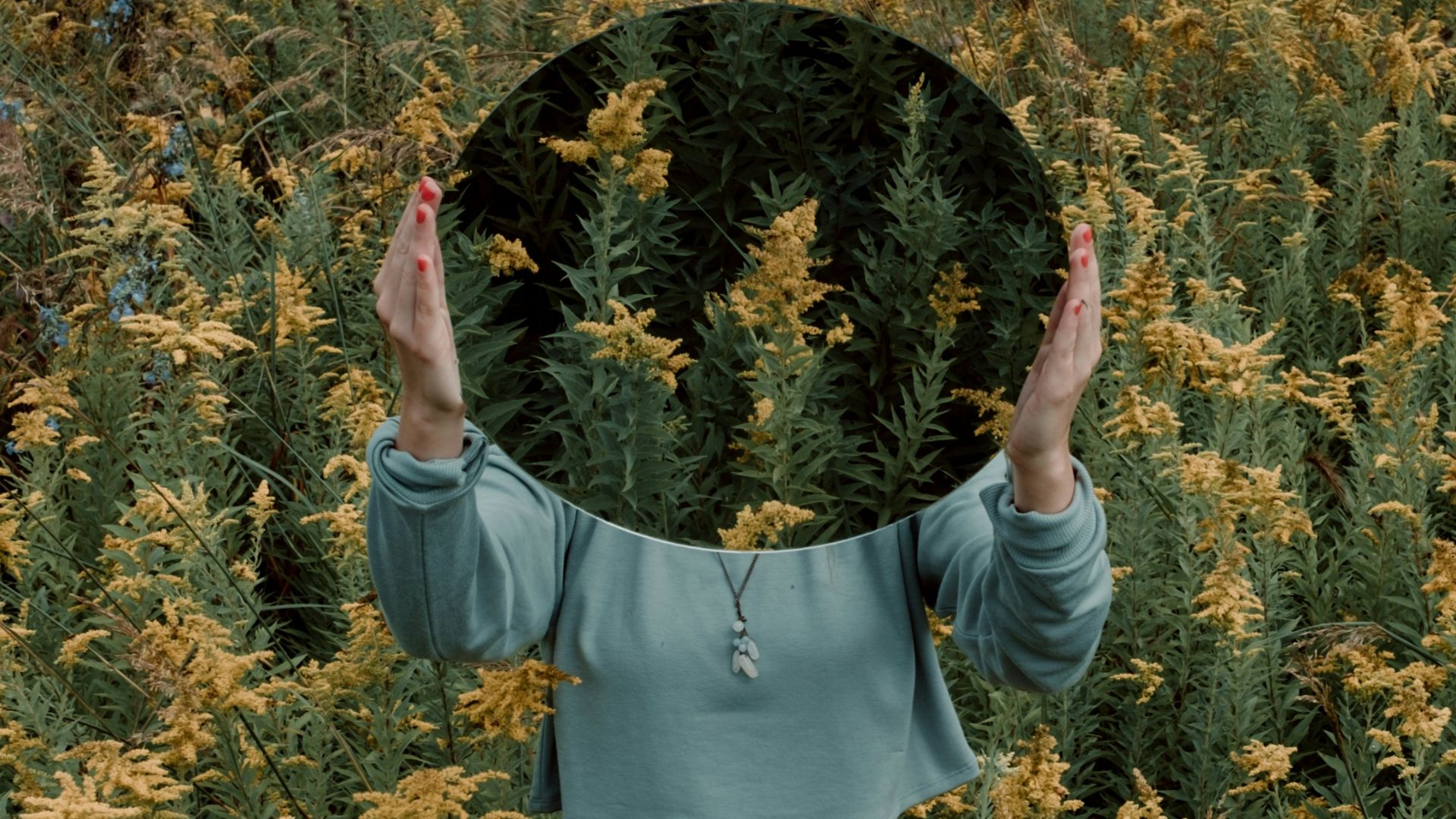 standing woman surrounded by yellow flower field during daytime