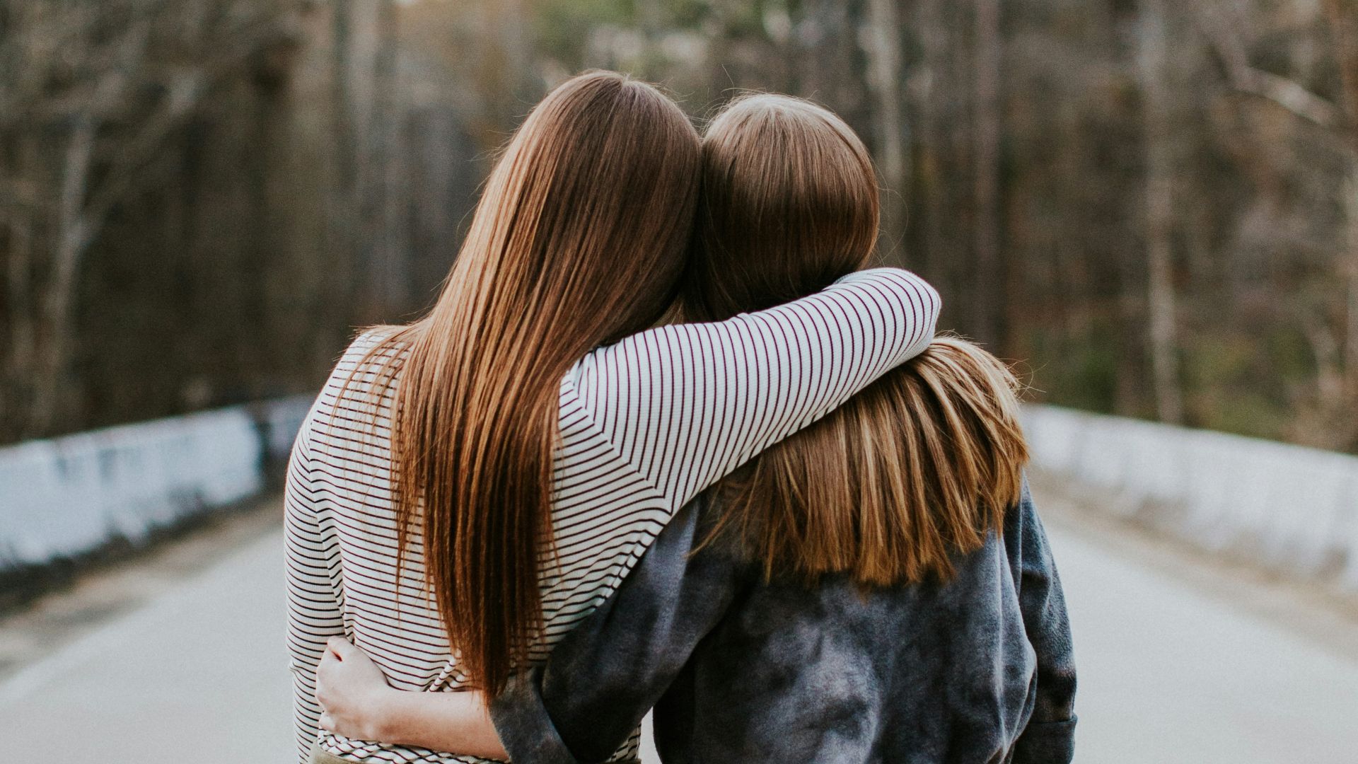 woman in black jacket standing on road during daytime