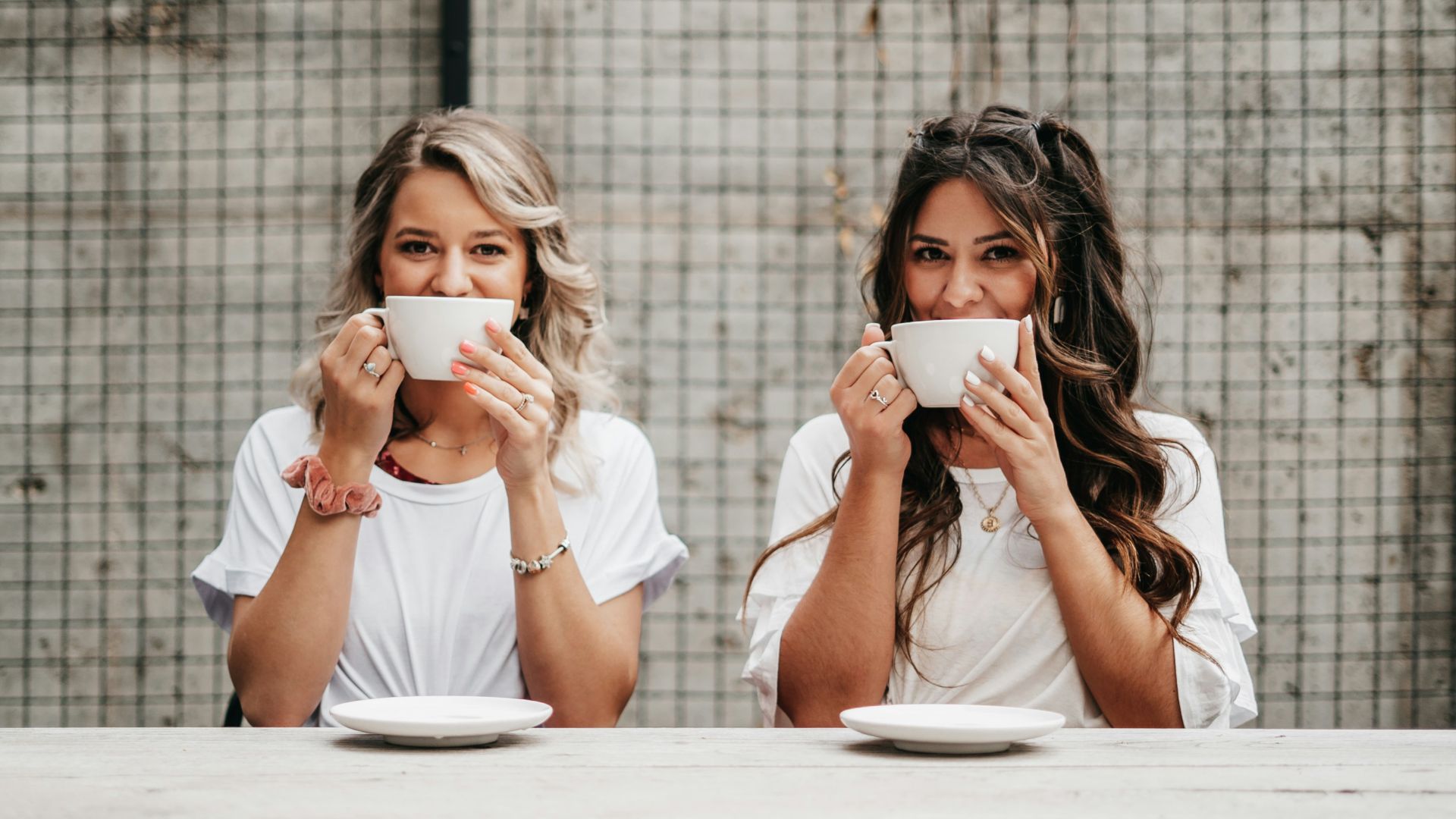 woman in white shirt drinking from white ceramic mug