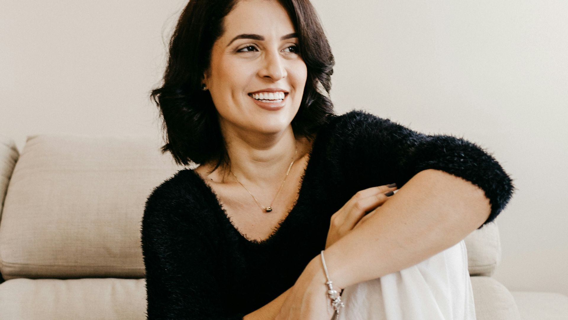 woman in black long sleeve shirt sitting on white couch