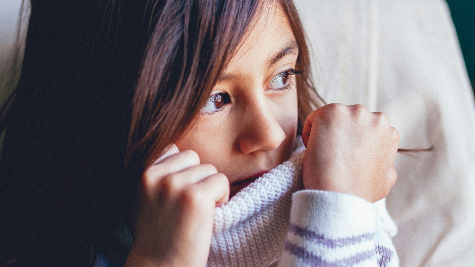 girl sitting on vehicle seat while looking at window