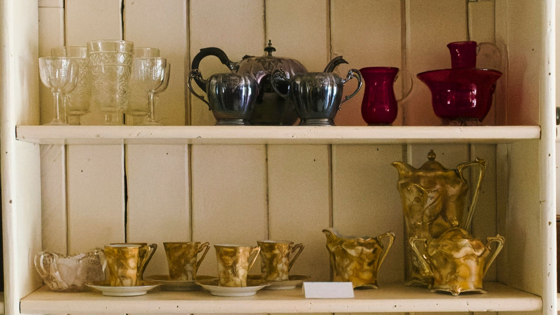 a white shelf filled with lots of dishes and cups