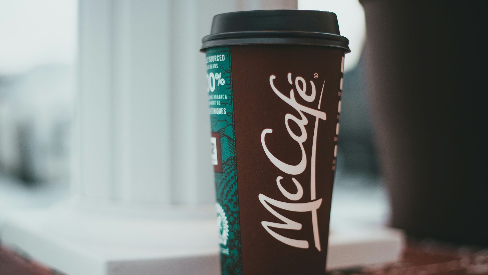black and white disposable cup on brown and black table