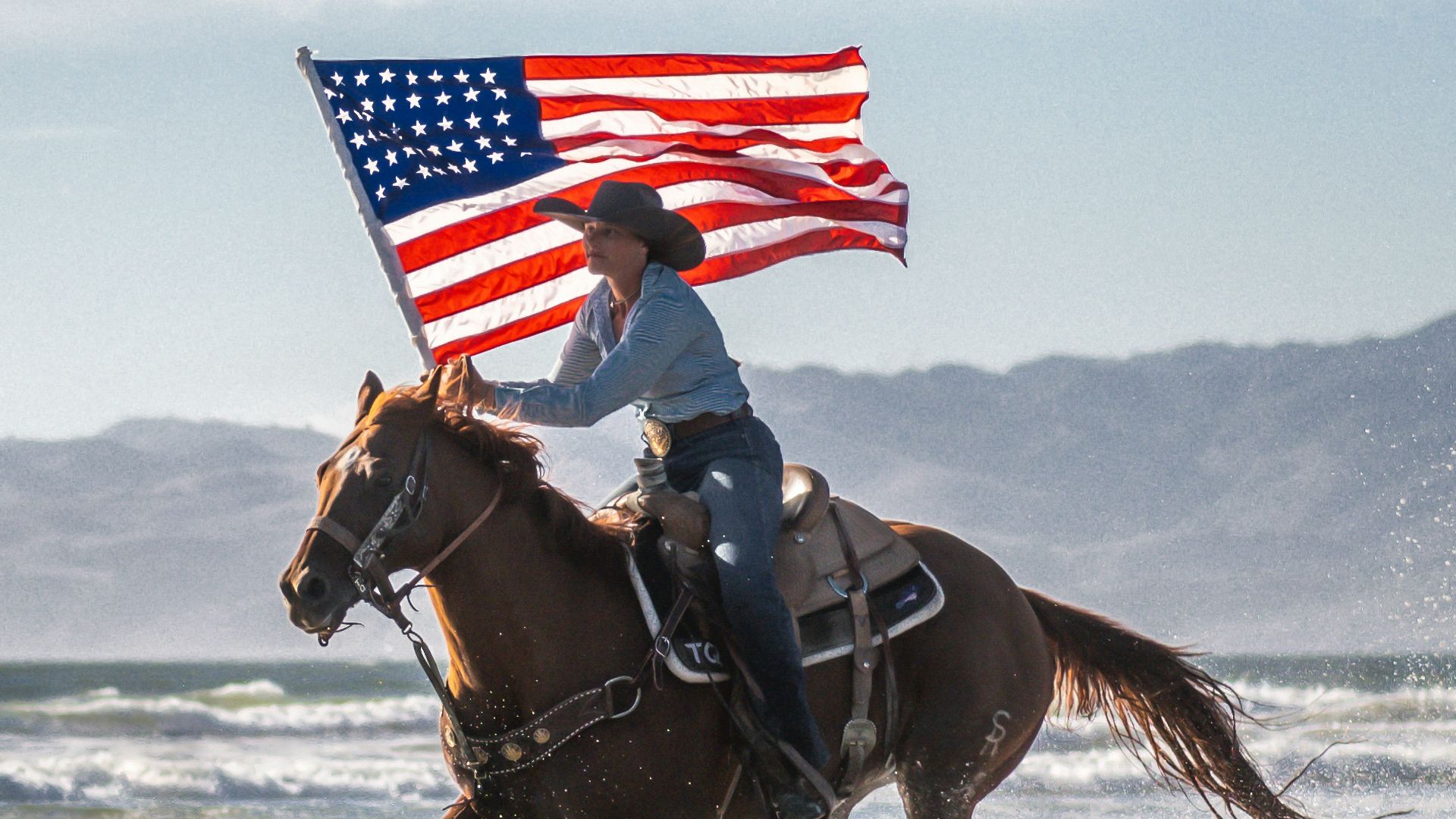 a person riding a horse with an american flag on its back