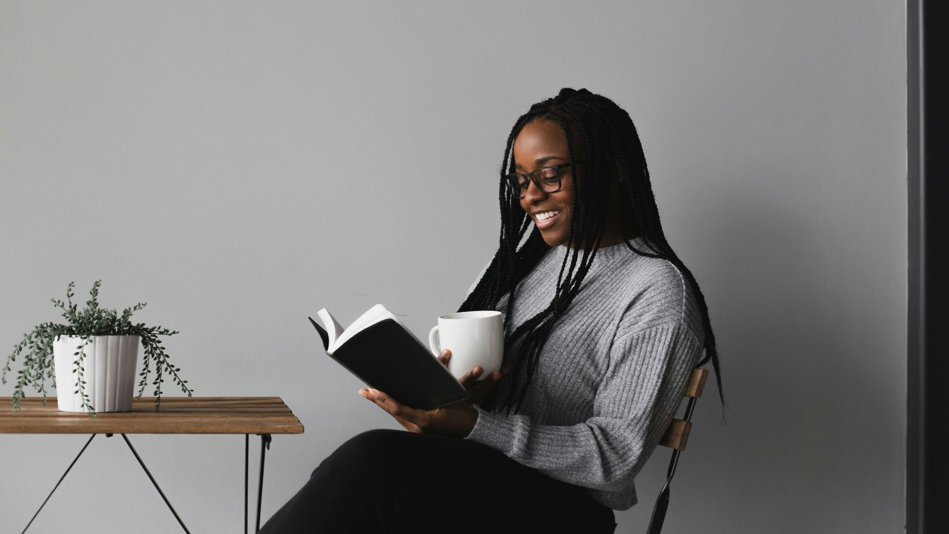 woman in white and black stripe long sleeve shirt sitting on chair