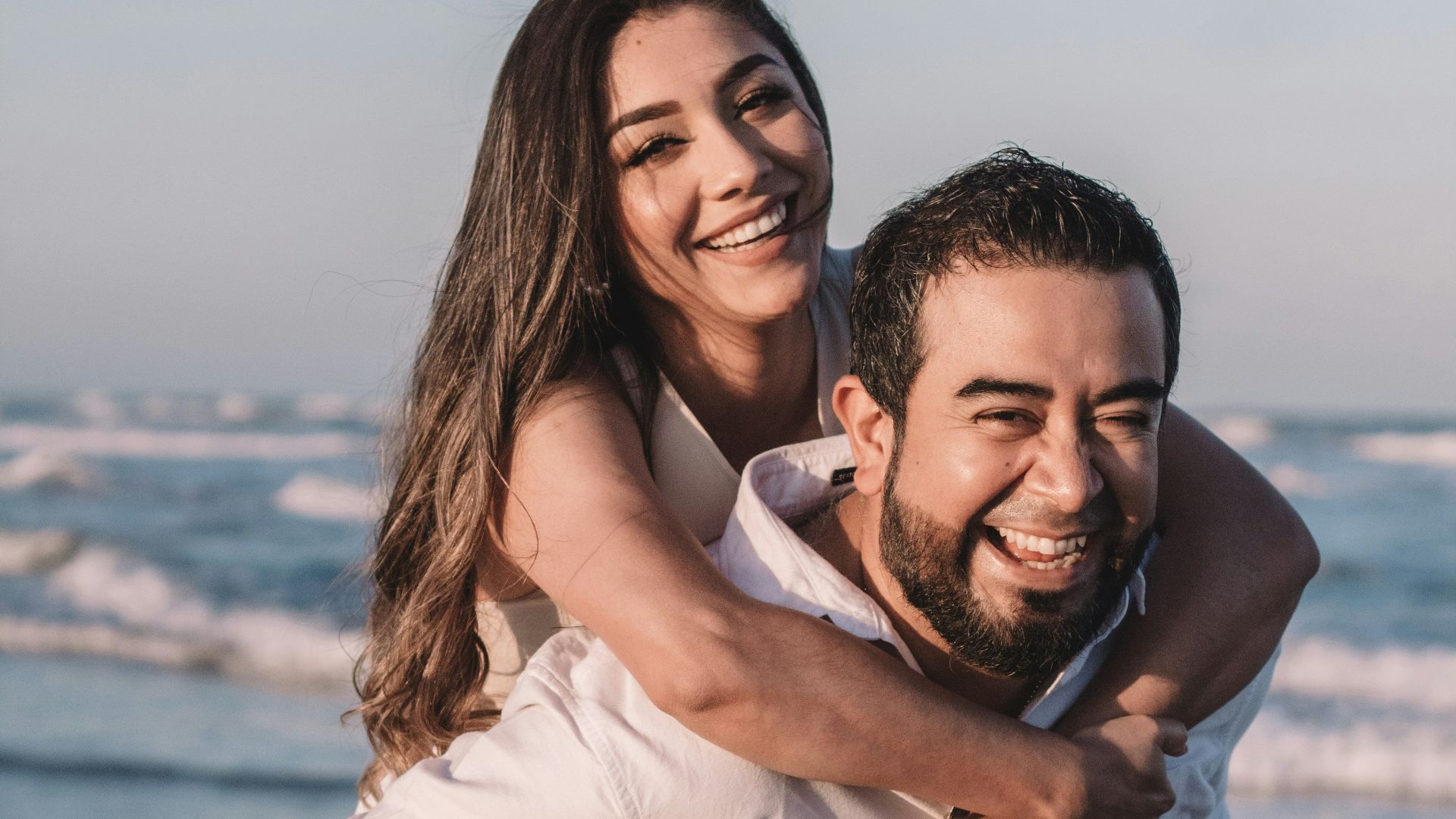man in white dress shirt hugging woman in white dress