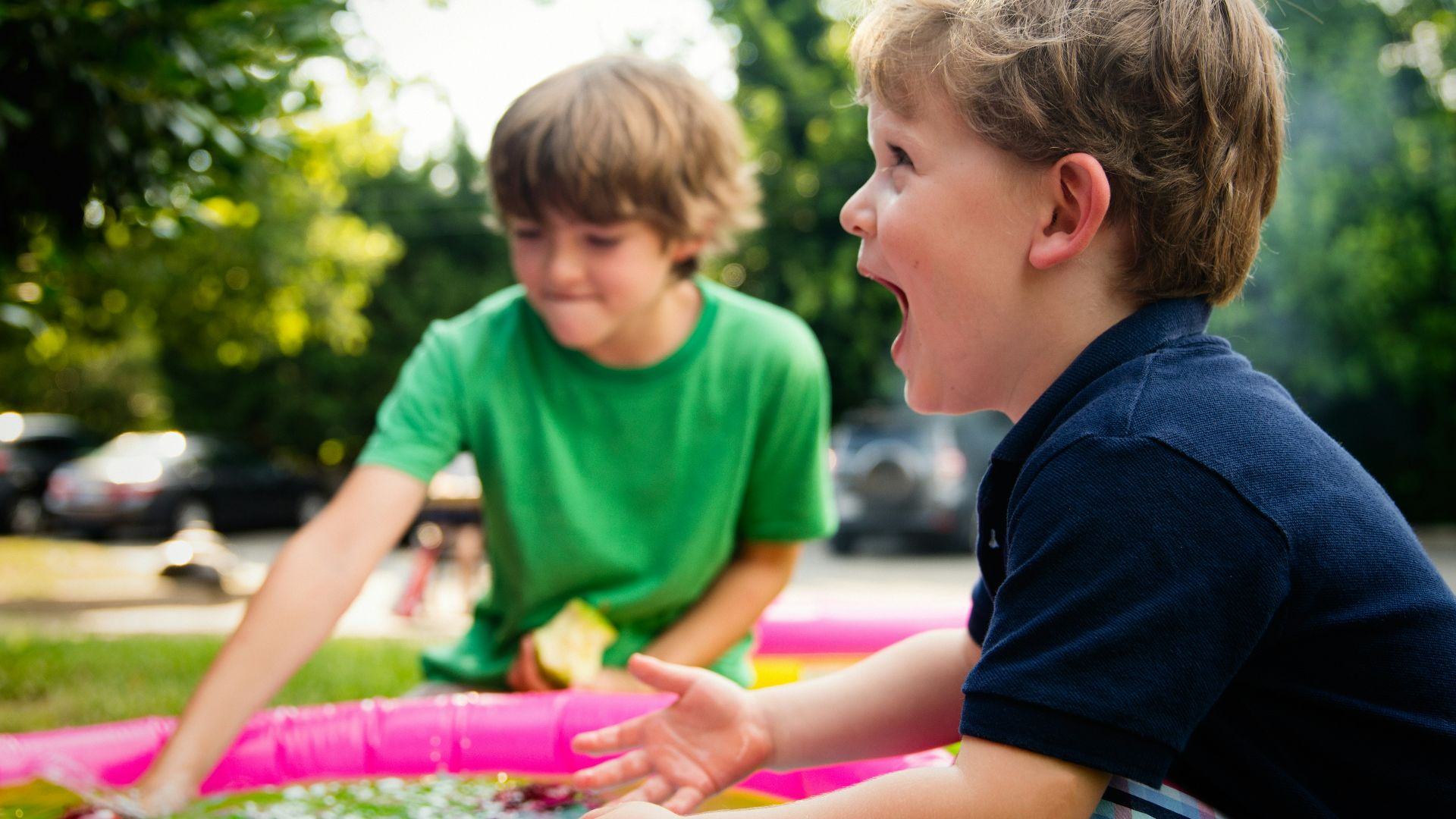 boy in blue shirt screaming near boy in green crew-neck shirt