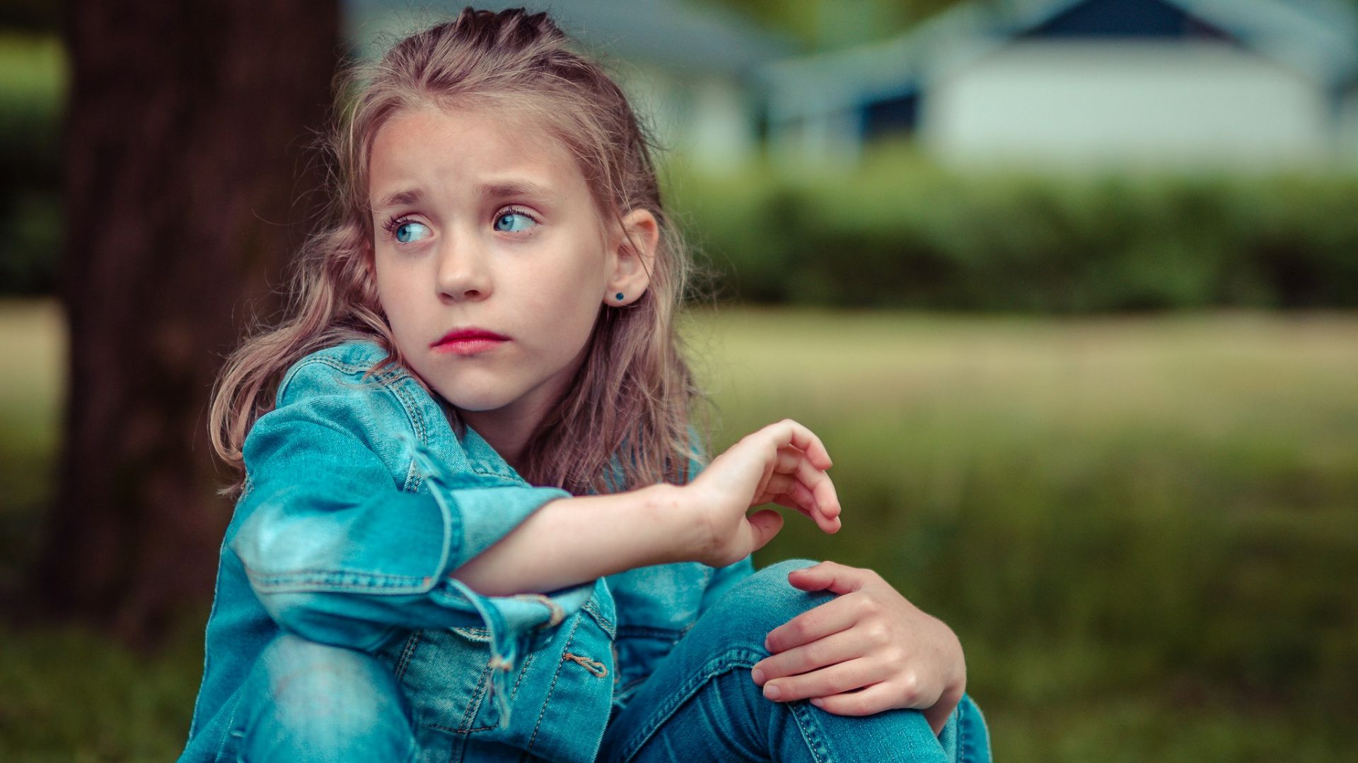 selective focus photography of girl sitting near tree