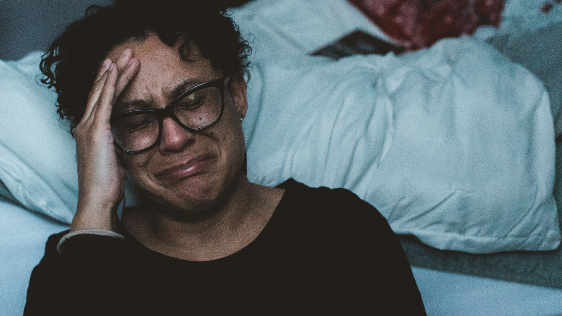 person crying beside bed