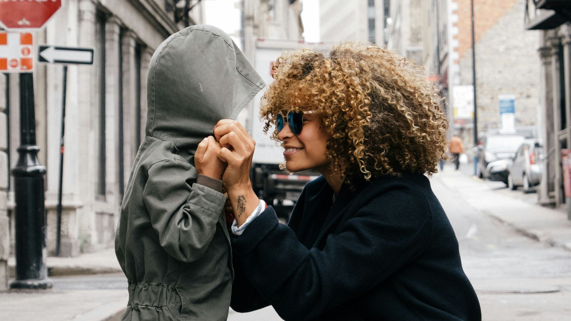 woman holding kid at the street