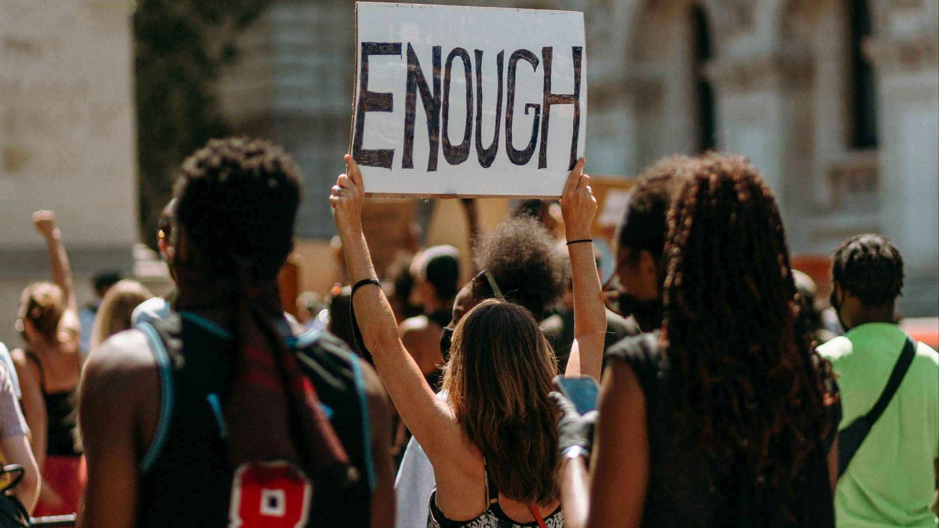 people holding a signage during daytime