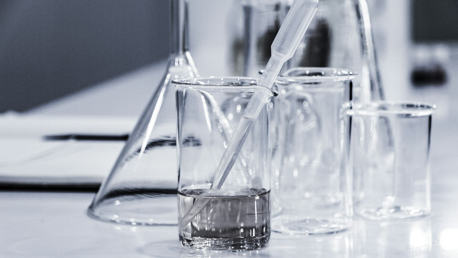 three clear beakers placed on tabletop