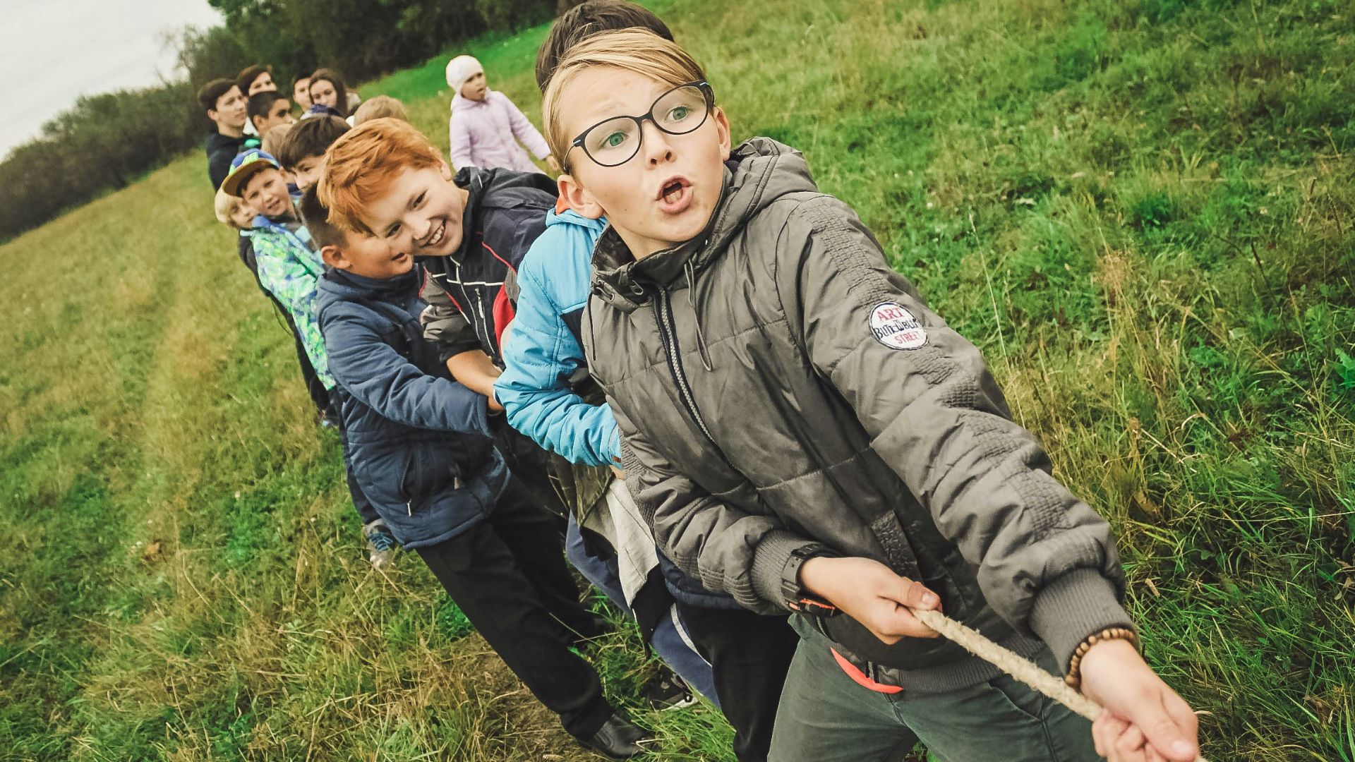 group of children pulling brown rope