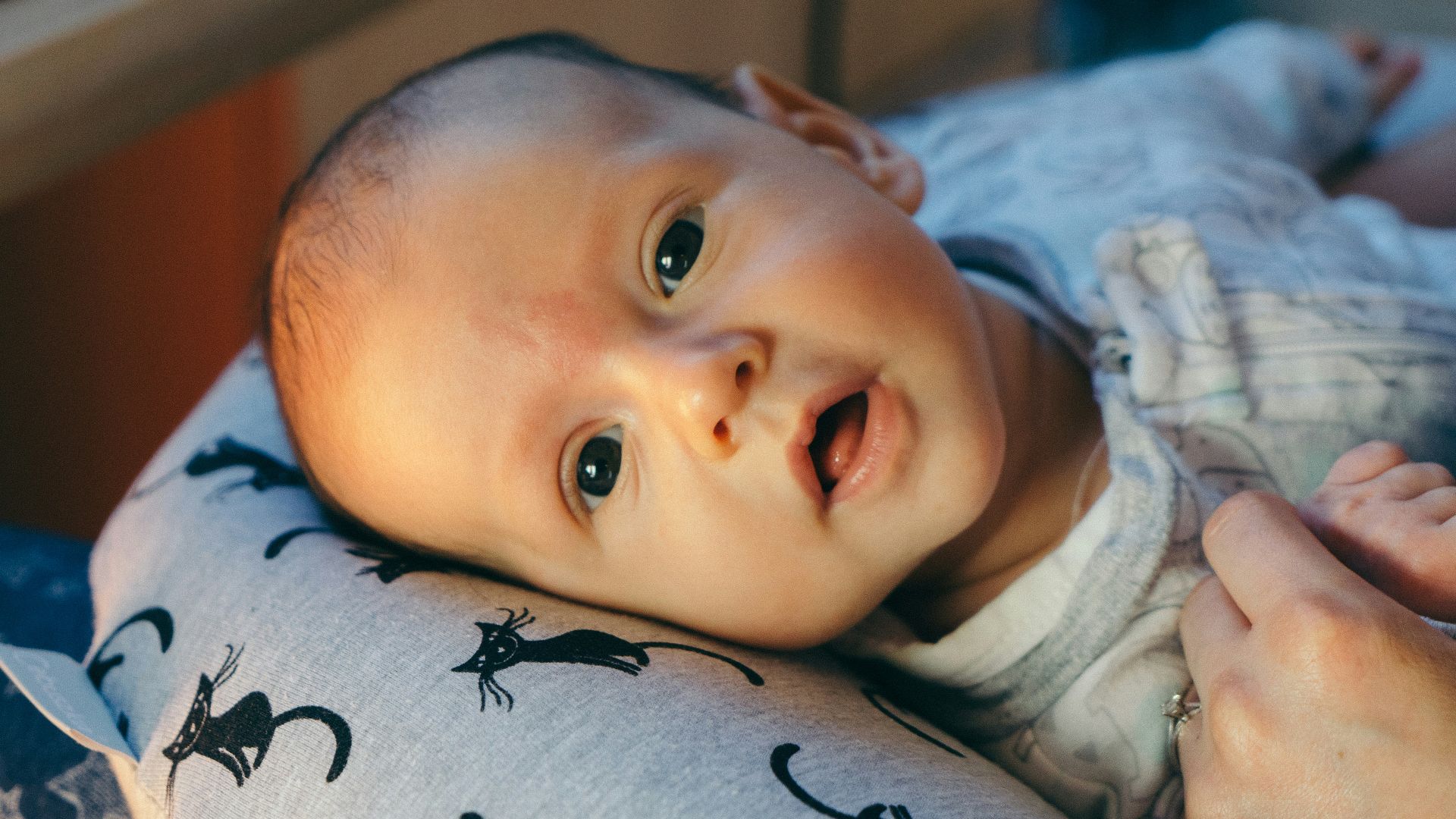 baby in white shirt lying on bed