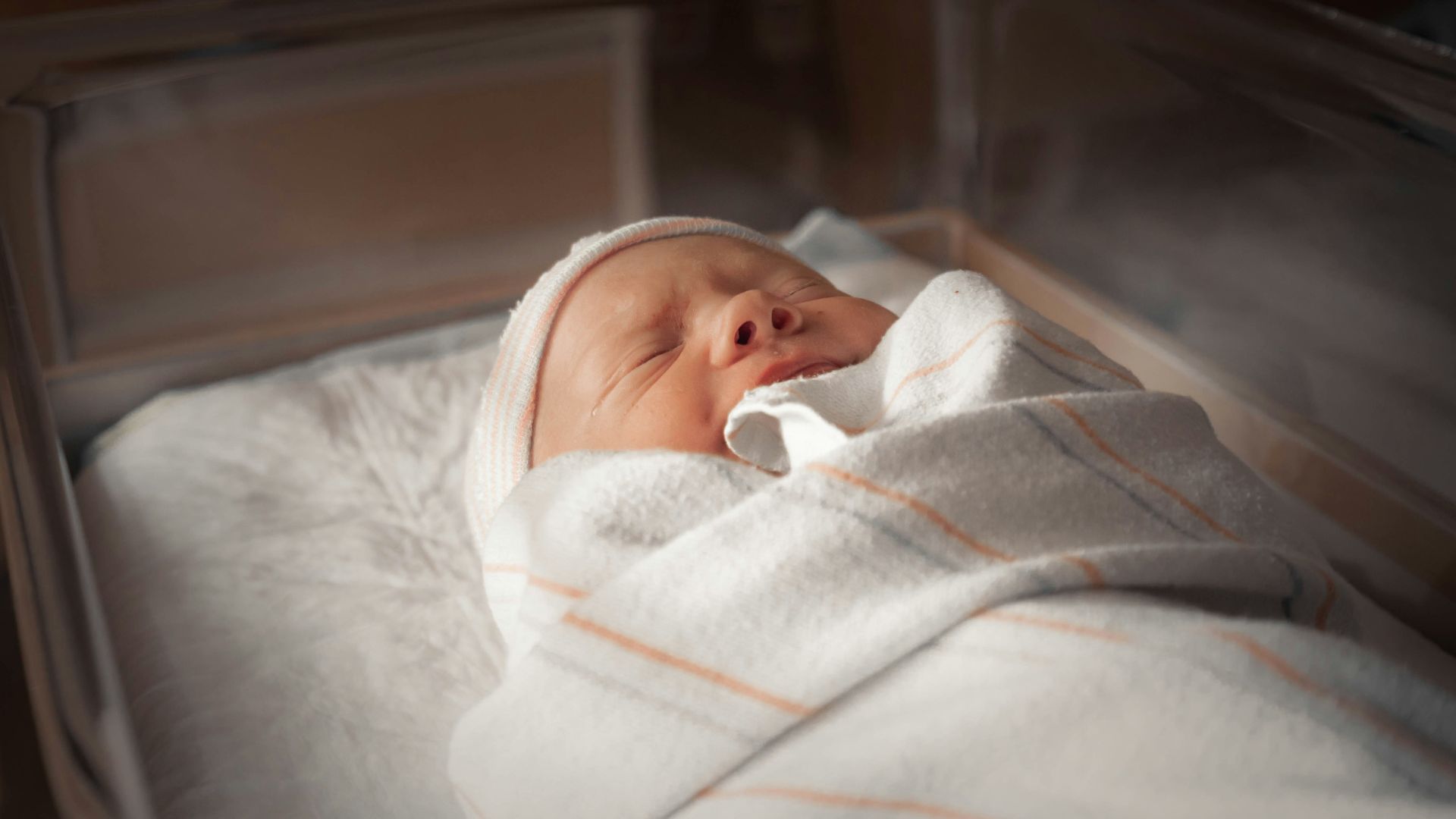 baby in white and pink blanket