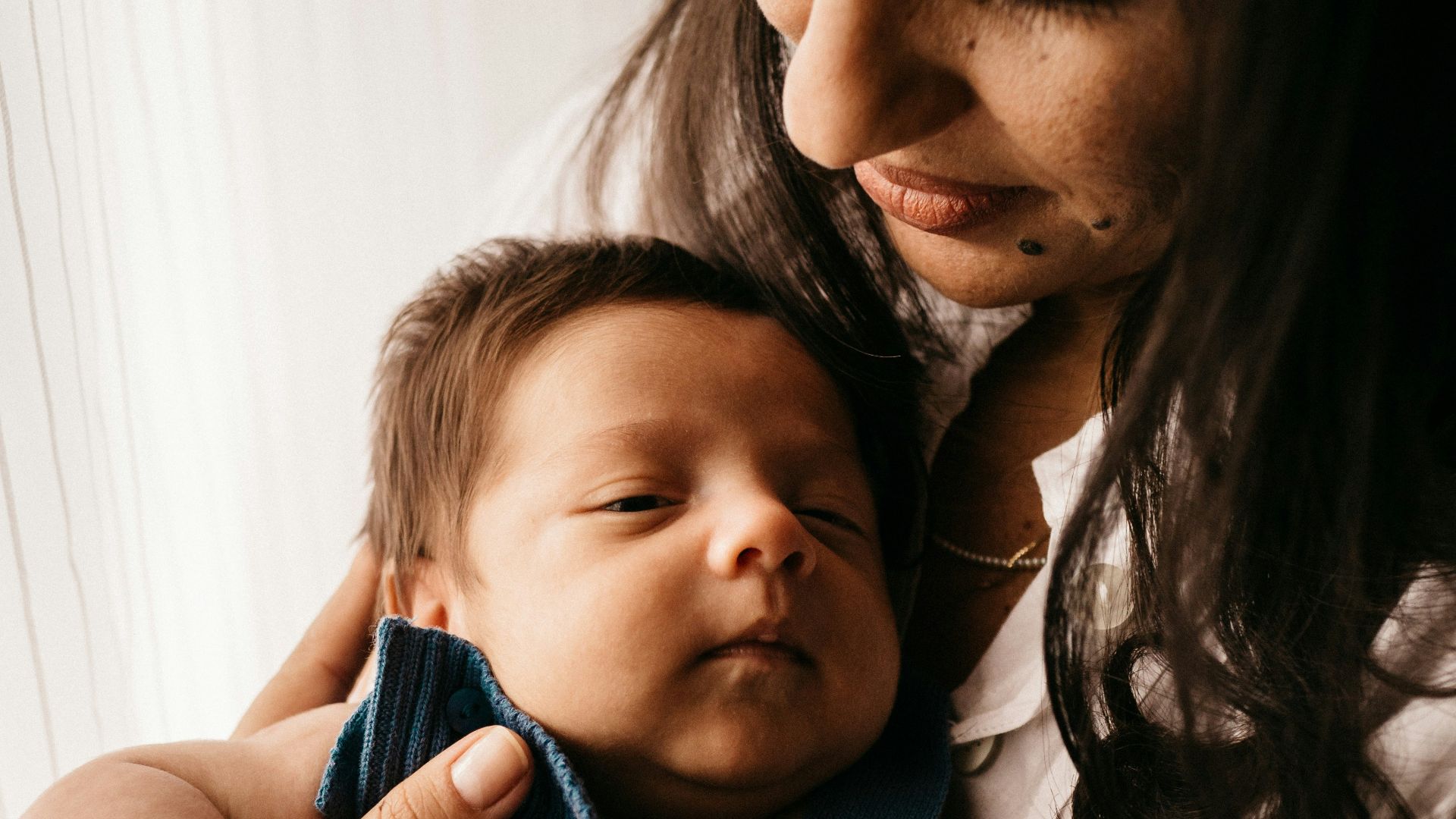 man in white shirt carrying girl in blue knit shirt