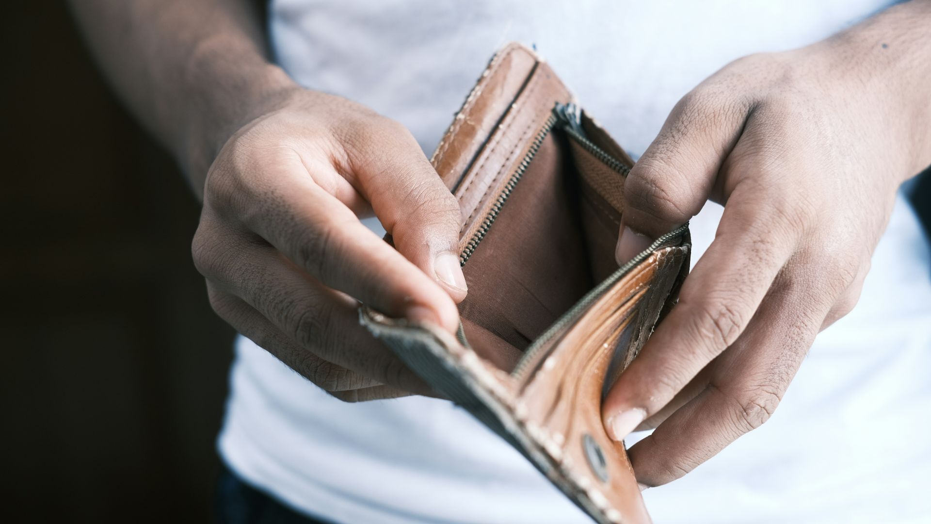person holding brown leather bifold wallet