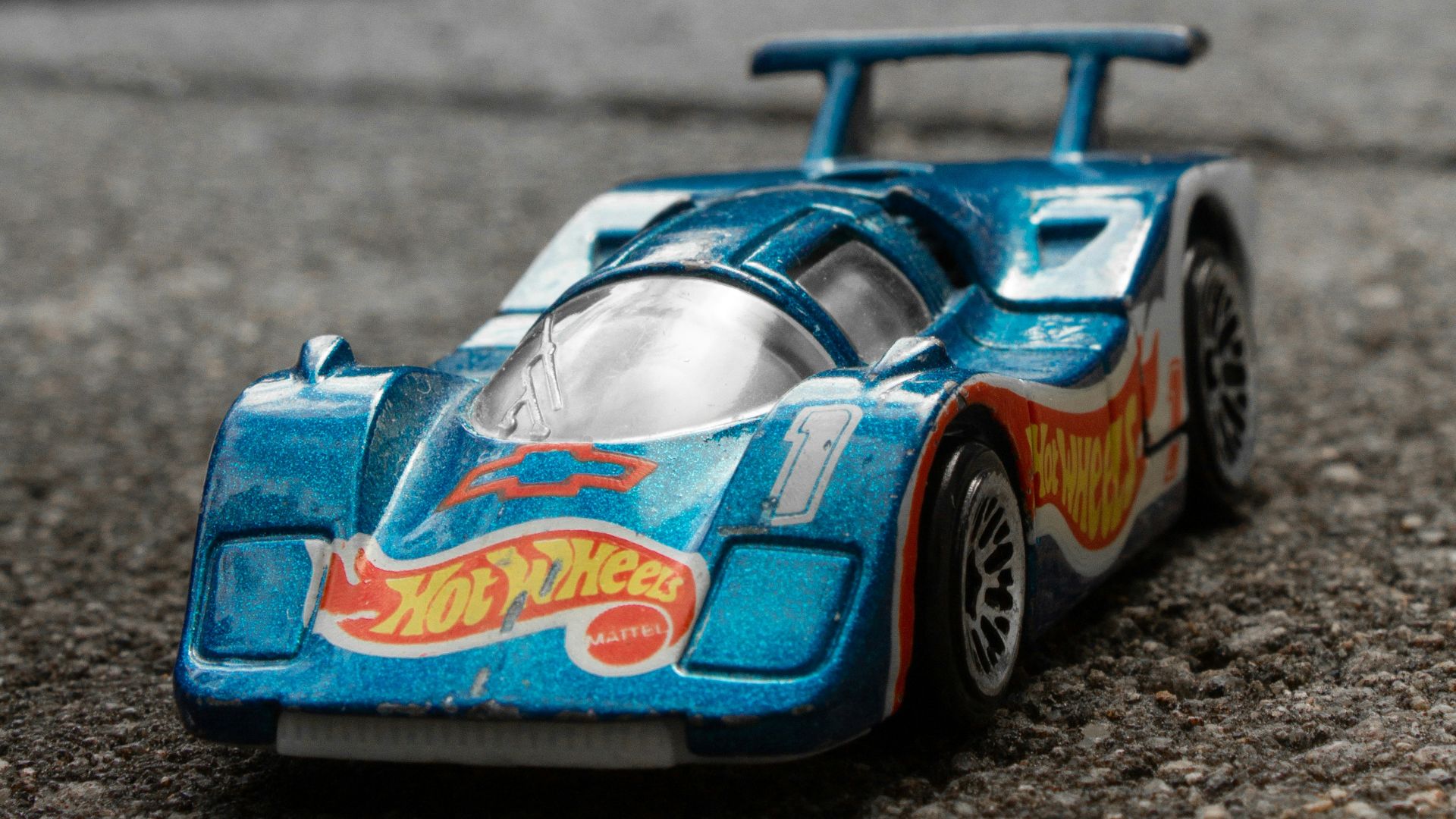 a blue toy car sitting on top of a street