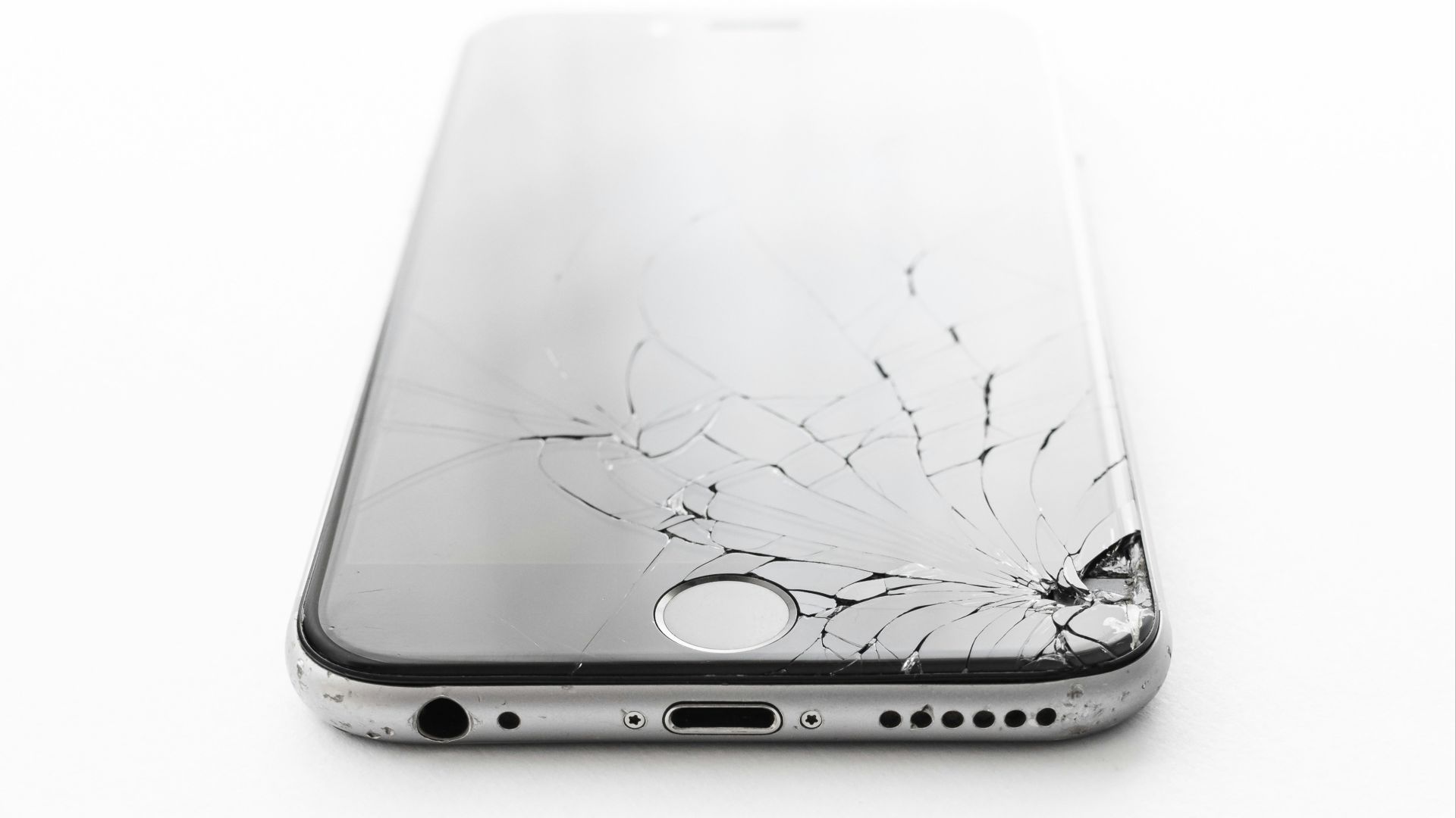 a broken cell phone sitting on top of a white table