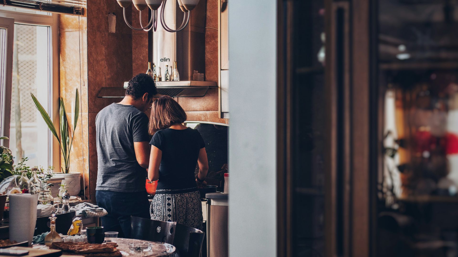 man and woman standing in front of gas range