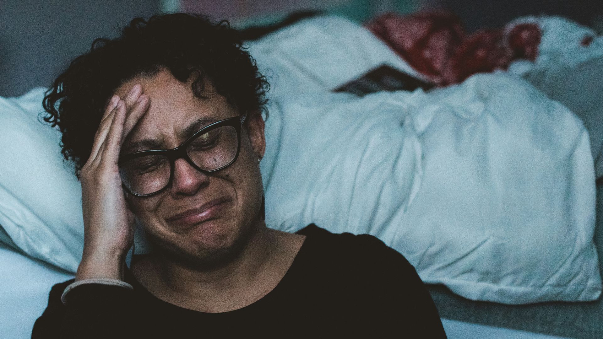 person crying beside bed
