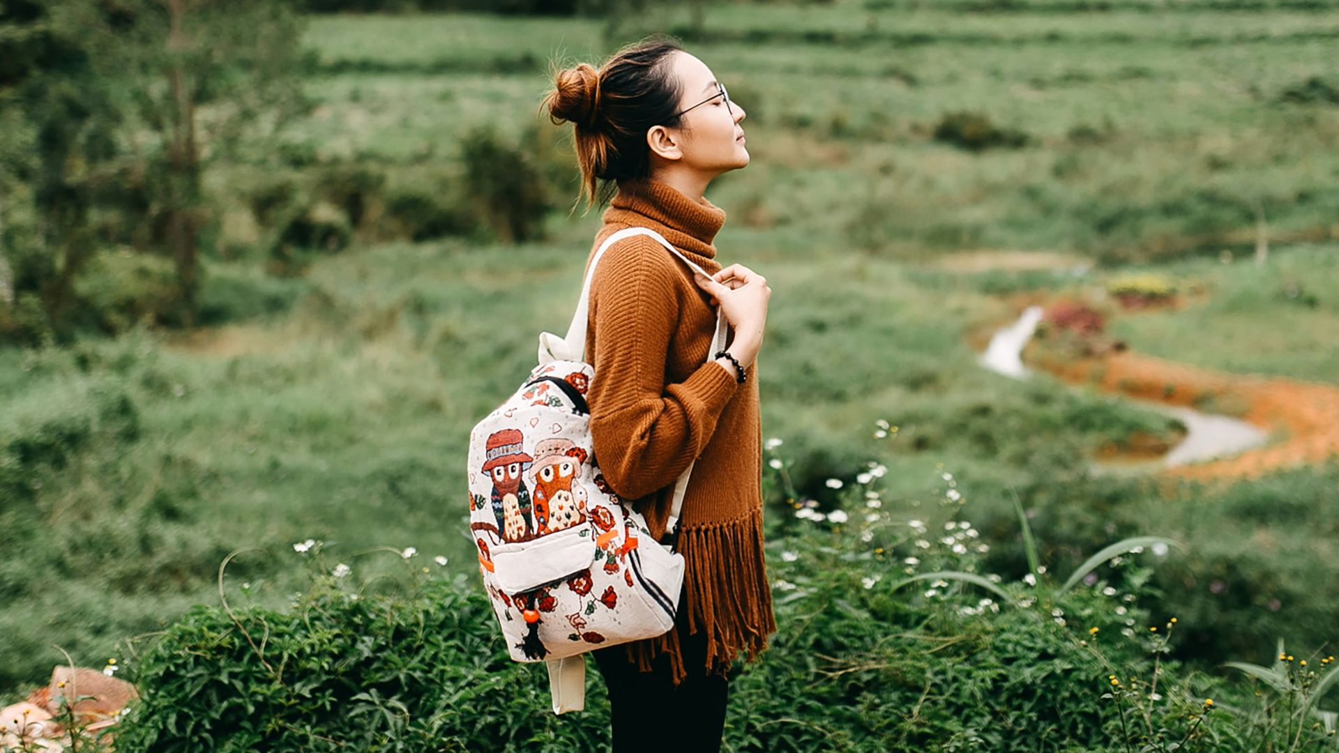 woman standing in the middle of grass field