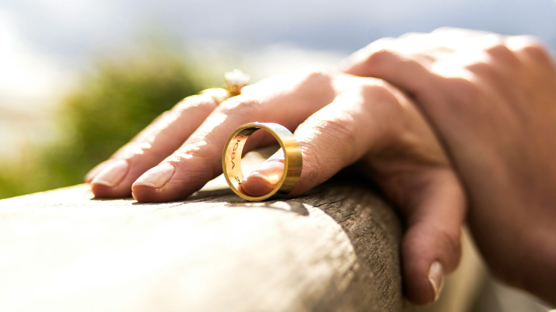 person holding gold wedding band