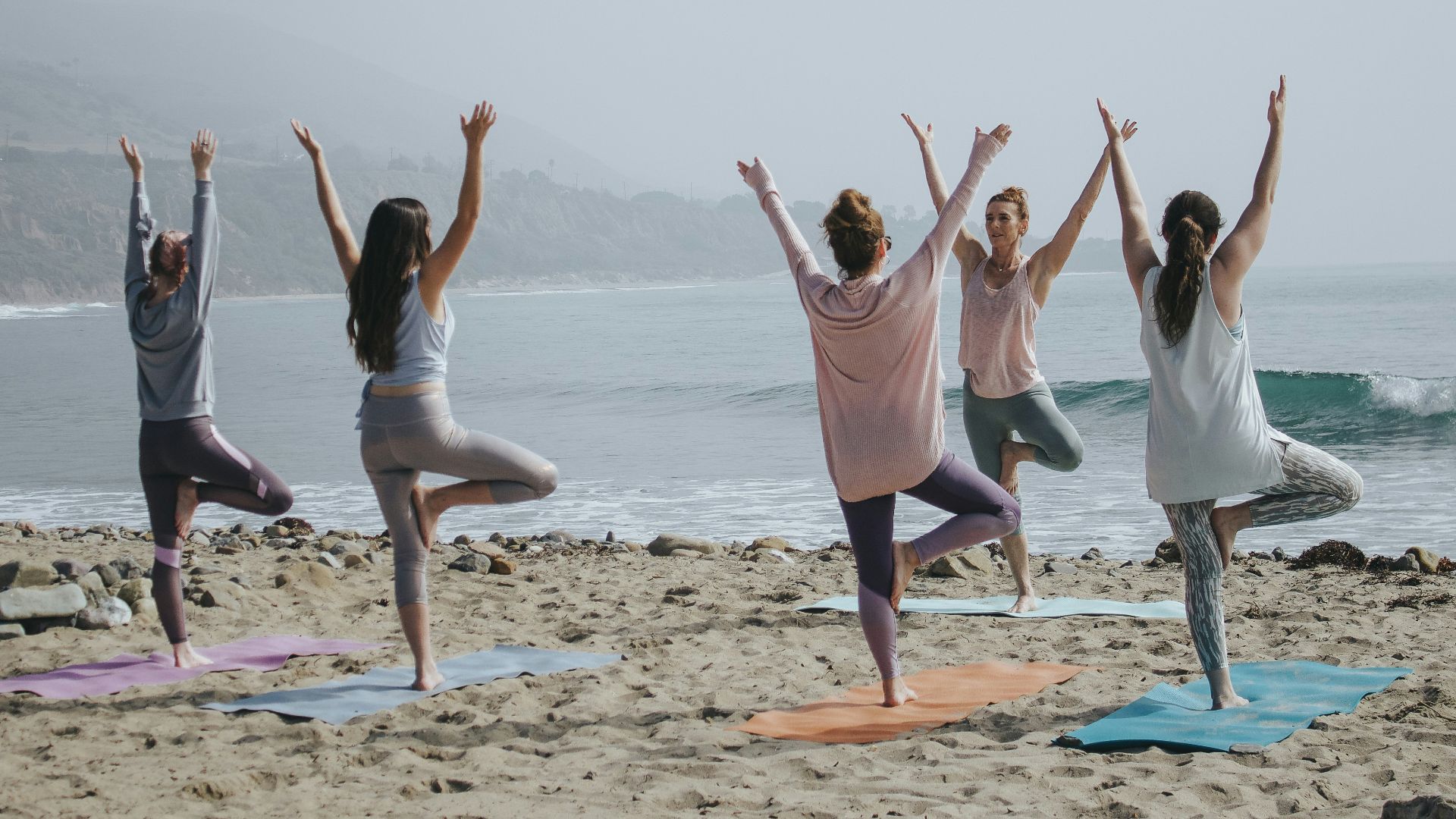 five woman standing on seashore