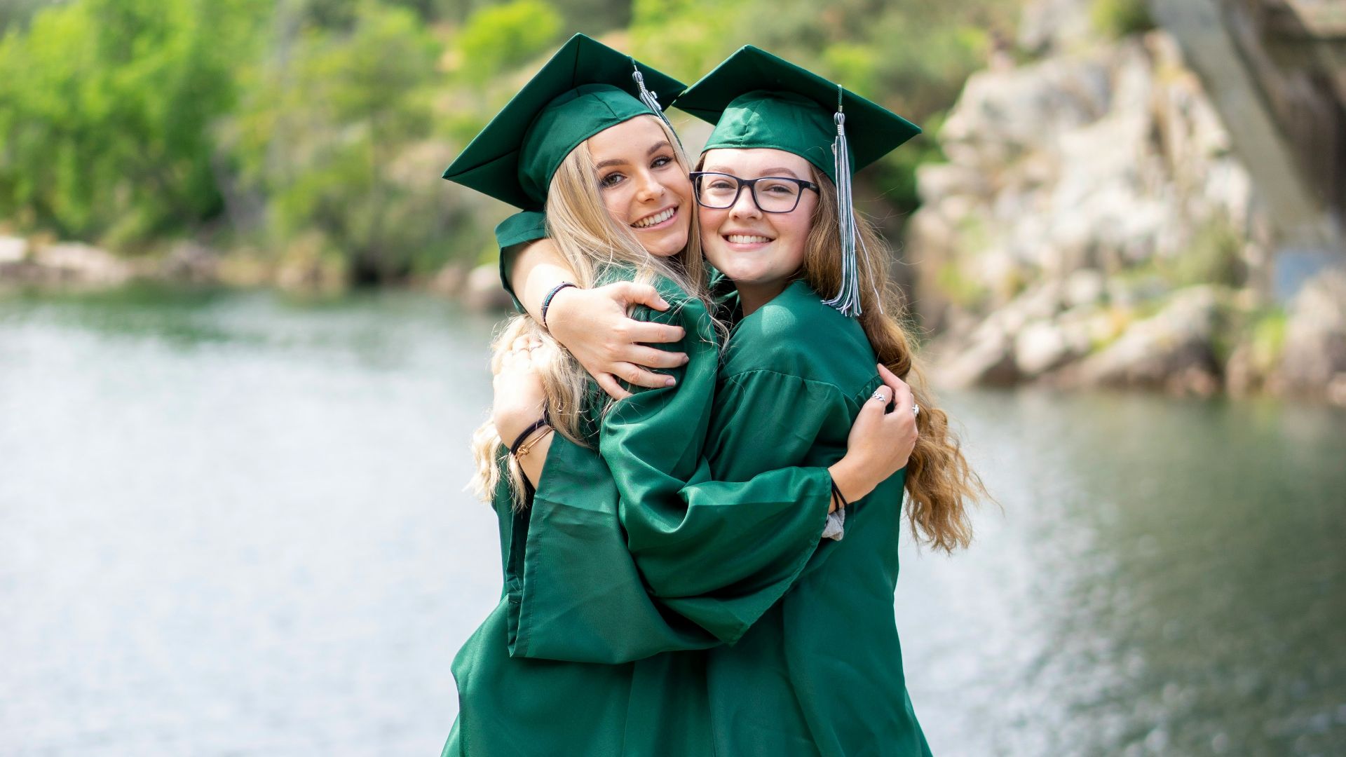 woman in green academic dress standing on gray concrete pavement during daytime