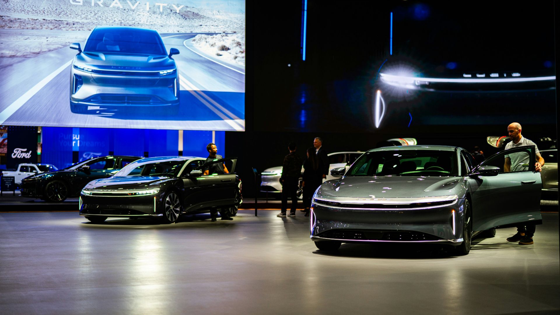 a group of people standing around a bunch of cars