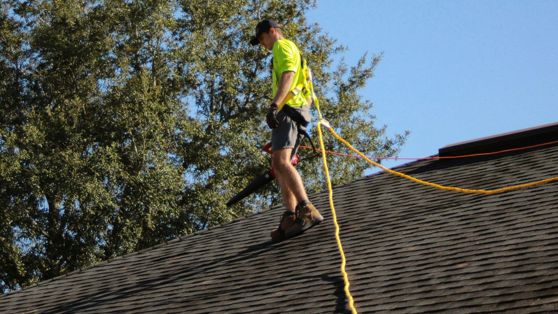 a man on a roof working with a rope