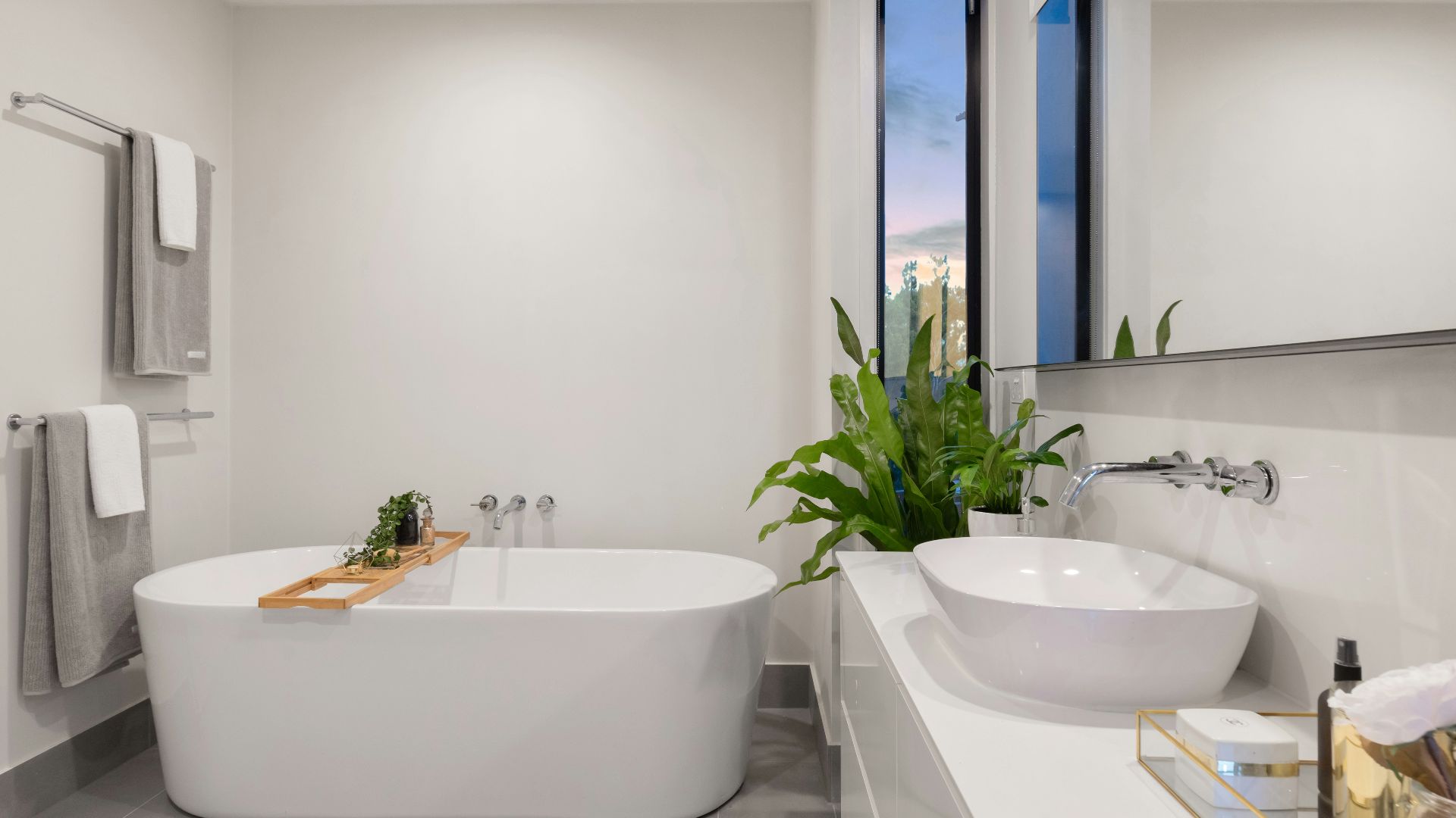 white ceramic bathtub near green potted plant