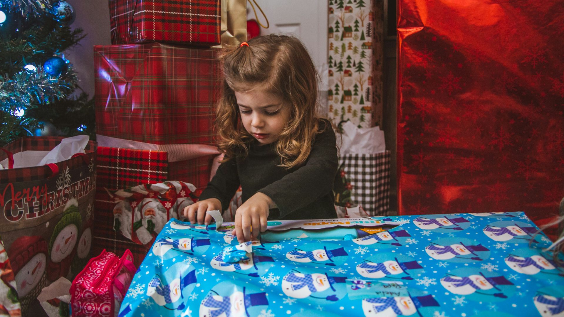 girl in black jacket sitting on blue and white table